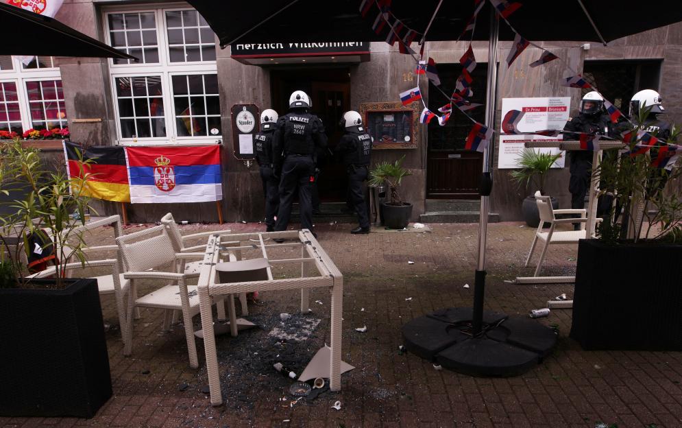 Police officers securing an area outside a damaged cafe.