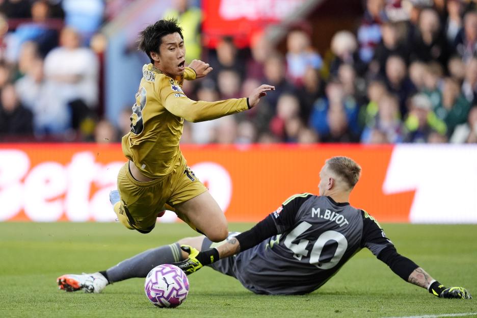 Crystal Palace's Daichi Kamada fouled by Aston Villa's goalkeeper Marco Bizot.