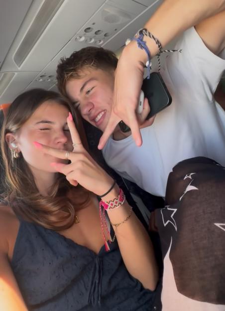 Couple making peace signs on an airplane.