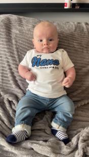 Baby boy wearing jeans and a shirt that says