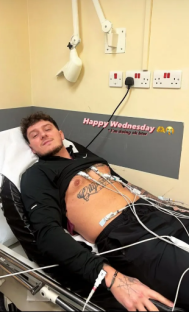 JJ Slater in a hospital bed connected to heart monitoring equipment.