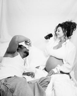 Black and white photo of a pregnant woman and a man lying in bed.