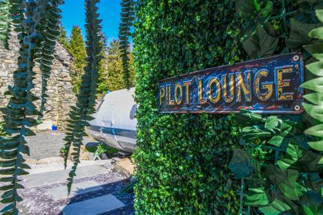 Pilot lounge sign on artificial hedge.