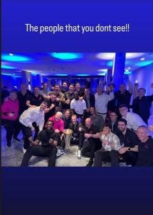 Large group of people celebrating with a trophy.