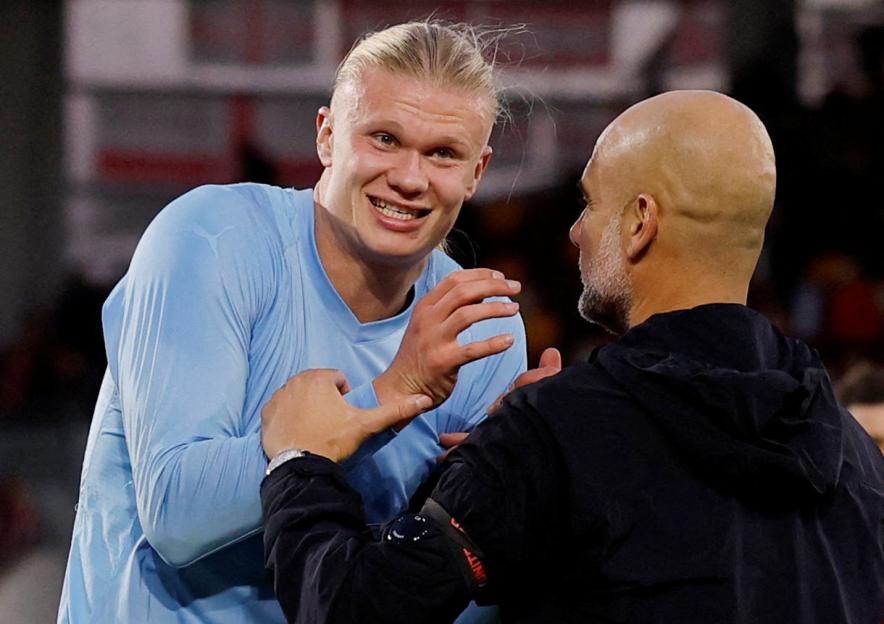 Manchester City's Erling Haaland and manager Pep Guardiola celebrate.