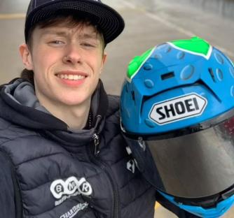 Owen Jenner, 21, holding a blue and green Shoei motorcycle helmet.