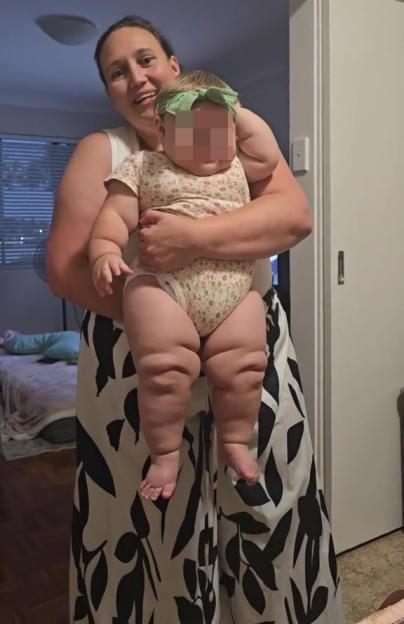A woman holding a six-month-old baby.