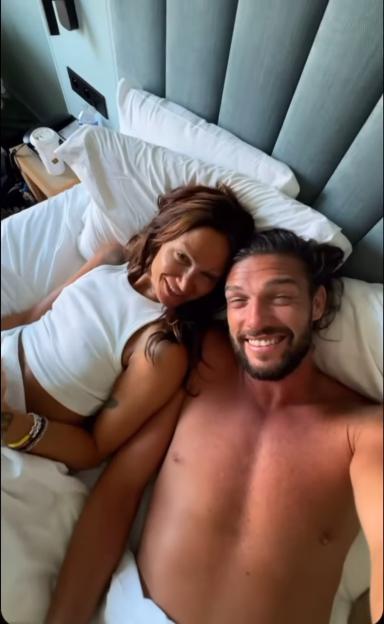 Andy Carroll and Lou Teasdale cuddling in bed.