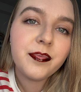 Close-up of a person's face with dark red lipstick.