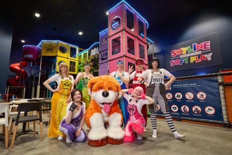 Group photo of costumed characters in a soft play area.