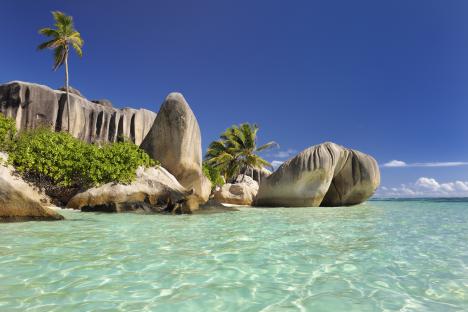 Famous beach Anse Source d'Argent with palm trees, clear water and sculpted rocks, La Digue Island, Seychelles, Indian Ocean