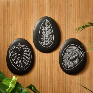 Three black wall plaques with white leaf illustrations.