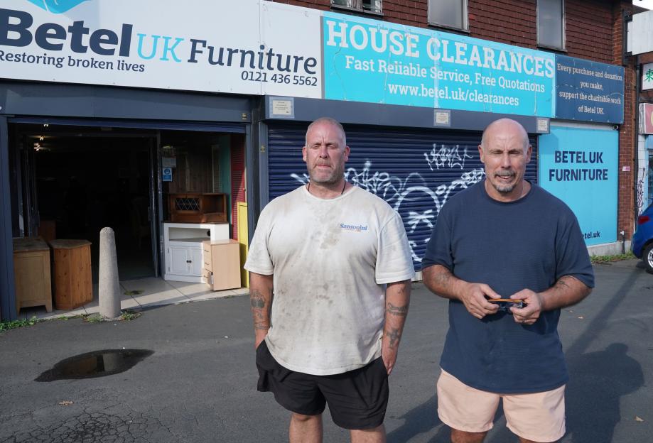 Two men standing outside a Bethel UK Furniture store.