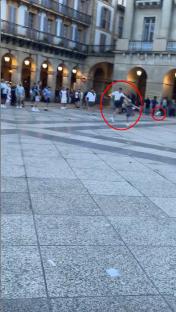 Video still of Tottenham and Manchester United fans arguing and kicking a football at each other in a plaza.