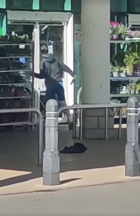 Screenshot of a person smashing a glass door with a weapon.