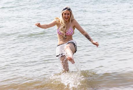 Woman splashing in water at Brighton Beach.