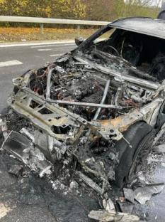 Burned-out car on the side of a road.