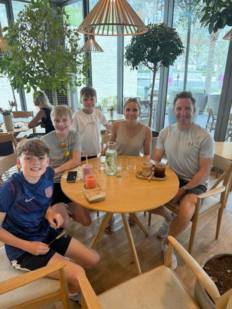 Family sitting at a cafe table with drinks.