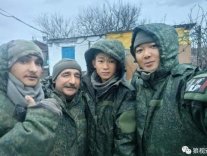 Photo of four soldiers in camouflage uniforms.