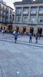 Tottenham Hotspur and Manchester United fans kicking a football at each other in a plaza.