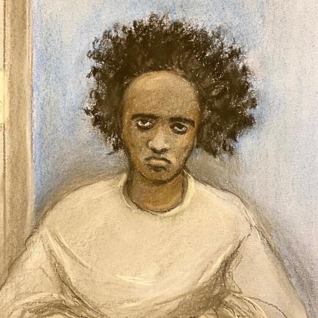 Courtroom sketch of Axel Rudakubana, a Black man with a serious expression and dark curly hair, wearing a light-colored top, sitting at a wooden table in a courtroom.
