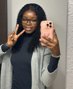 Selfie of a young woman making a peace sign.