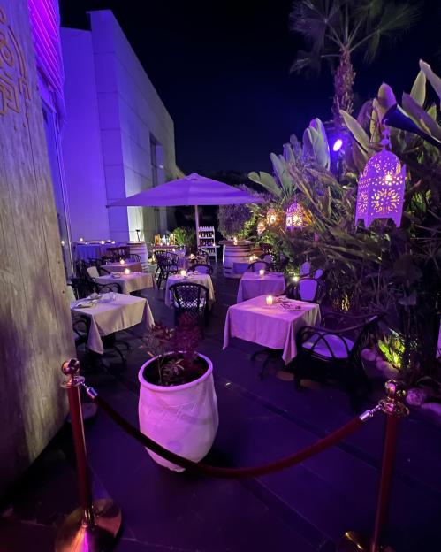 a restaurant with purple lights and tables and chairs