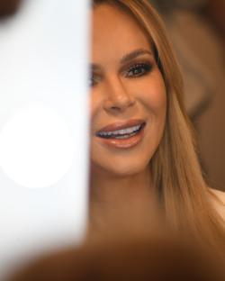 Amanda Holden smiling, partially obscured by a white surface.