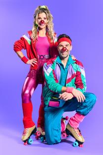 Two people in 1980s-style roller skating outfits with red clown noses.