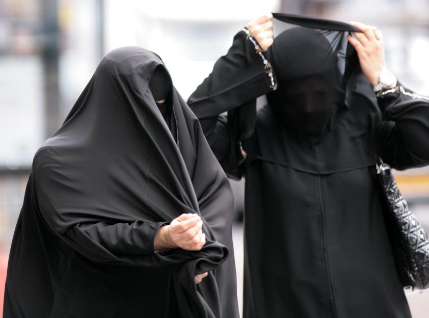 Women adjusting burkas