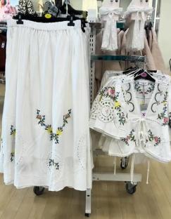 White embroidered skirt and top displayed in a store.