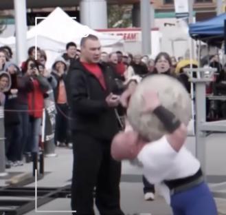 Strongman lifting a large stone.