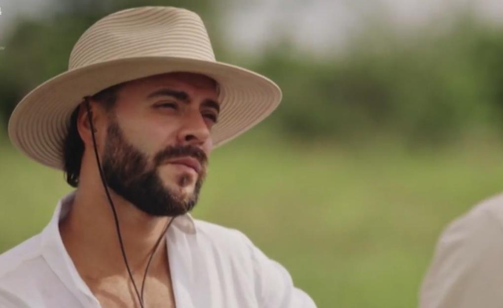 A man in a straw hat and white shirt.