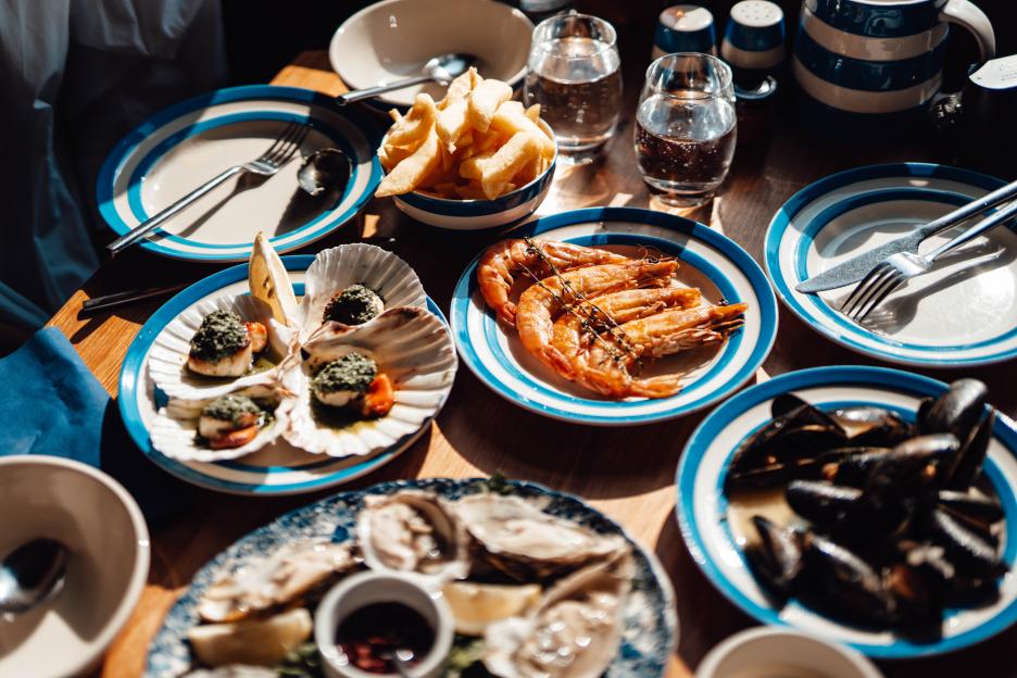Seafood platter with oysters, scallops, prawns, and mussels.