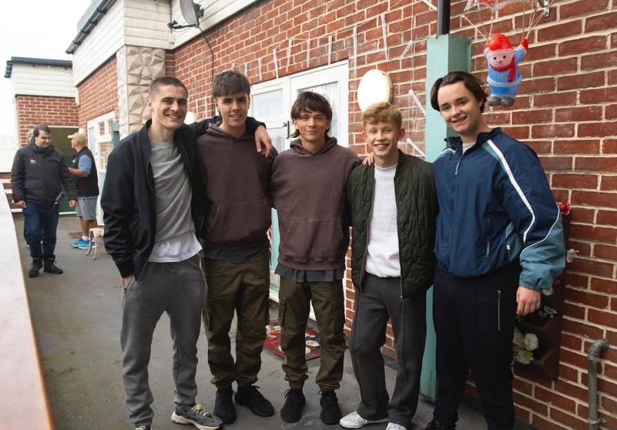 Five young men posing for a photo.