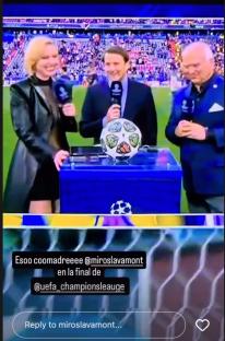 Three sportscasters with microphones stand at a table with the UEFA Champions League trophy.
