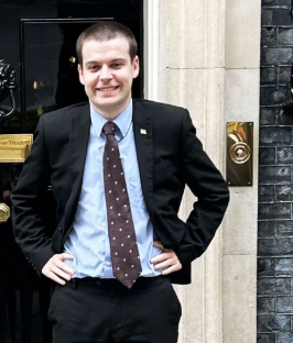 Man in suit standing outside building.