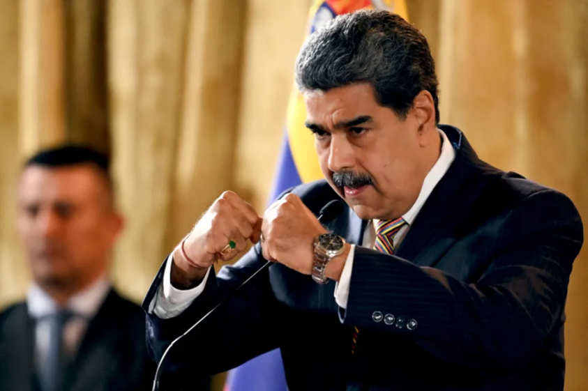Nicolás Maduro speaking at a podium.