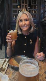 Woman holding a cocktail in a restaurant.