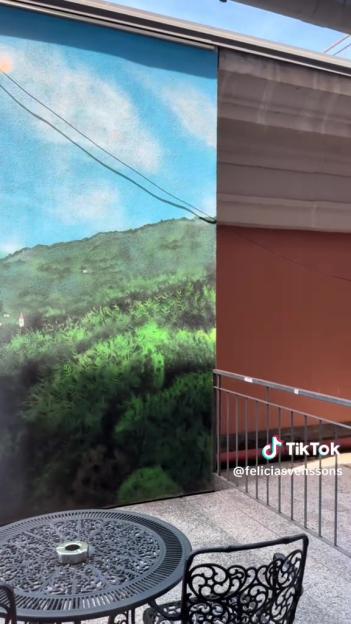 Hotel balcony with painted landscape mural.