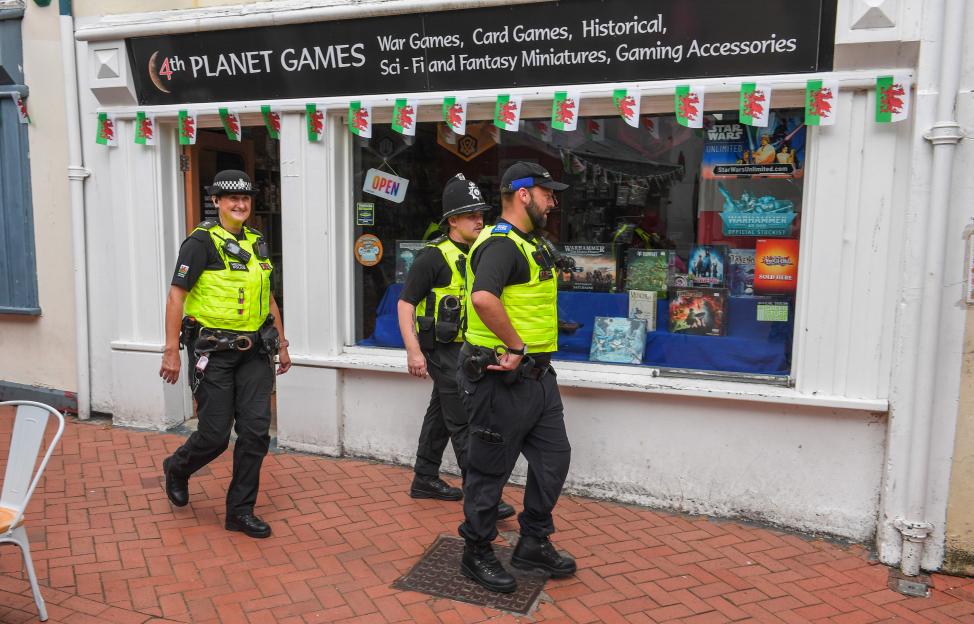 Police officers on patrol outside a game shop.