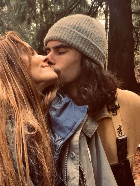 Isabel Lucas being kissed by a man with a mustache in a forest setting.