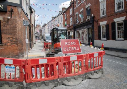 Road closed sign and barriers blocking a street during roadworks.