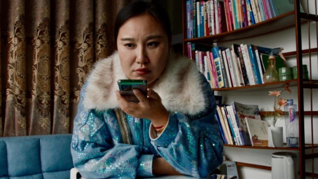 Still from the film *Mistress Dispeller*, directed by Elizabeth Lo. A woman uses a smartphone.