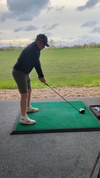 Golfer preparing to hit a golf ball.