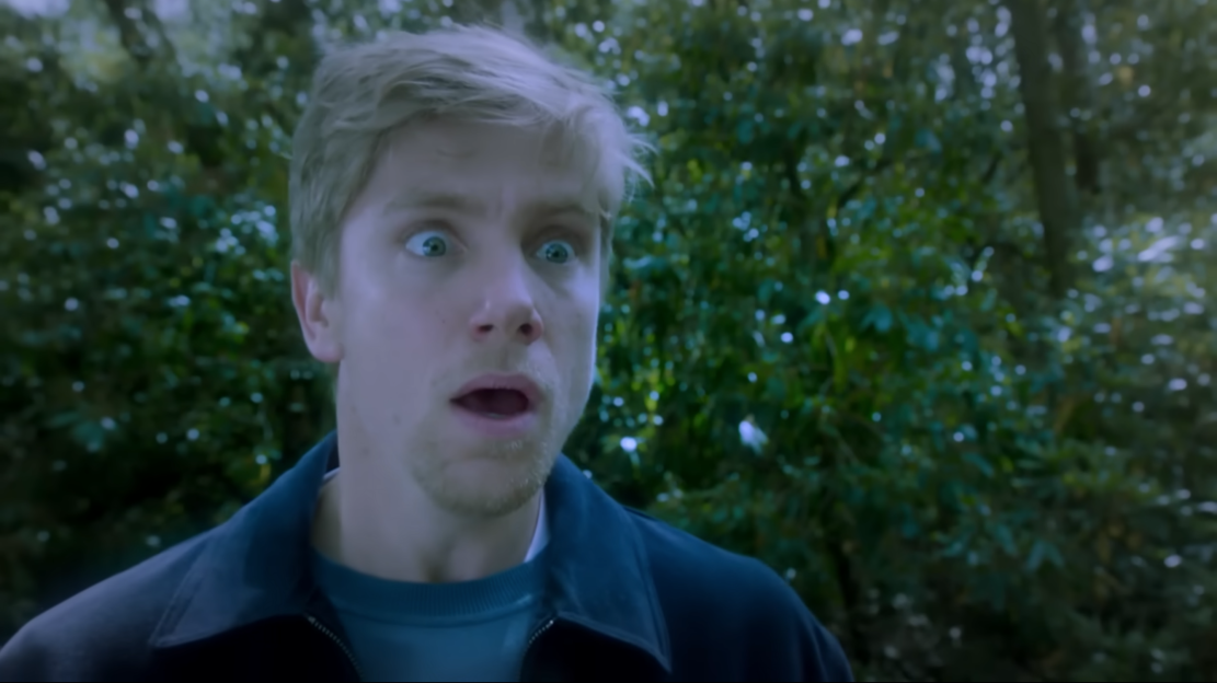 Screenshot of a surprised young man.