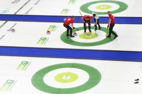 Scotland skip Bruce Mouat sweeps a Scottish stone in the button as Canada's Brett Jacobs, Marc Kennedy and Ben Hebert look on during their teams' session at the men's world curling championship in Moose Jaw, Saskatchewan, Monday, March 31, 2025. (Chris Young/The Canadian Press via AP)