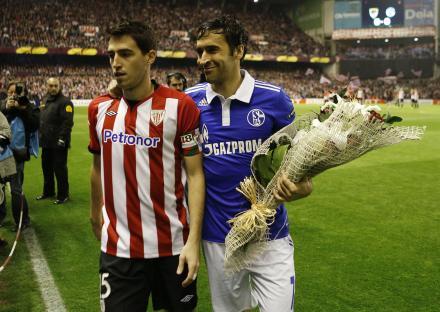 Two soccer players holding a bouquet of flowers.