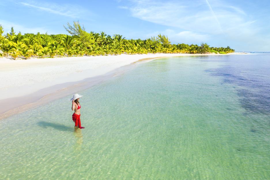 Woman in red sarong standing in the Caribbean Sea.