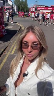 Woman in sunglasses outside a football stadium.